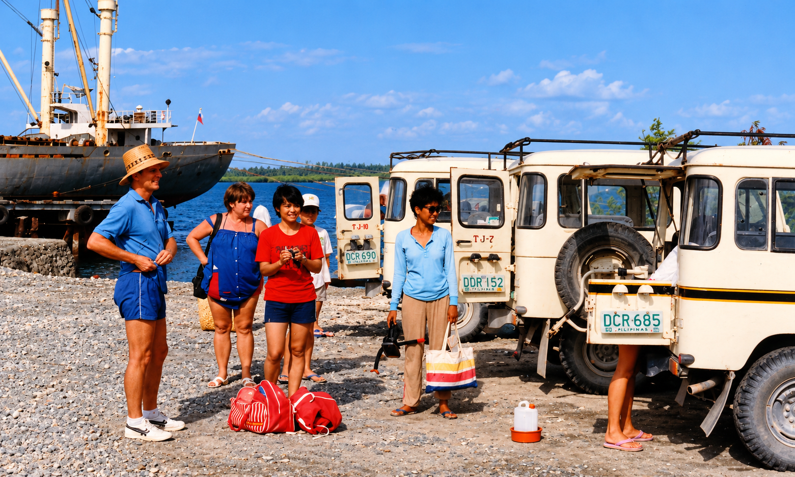 A group beside white Land Cruisers at a port, with a cargo ship behind them.