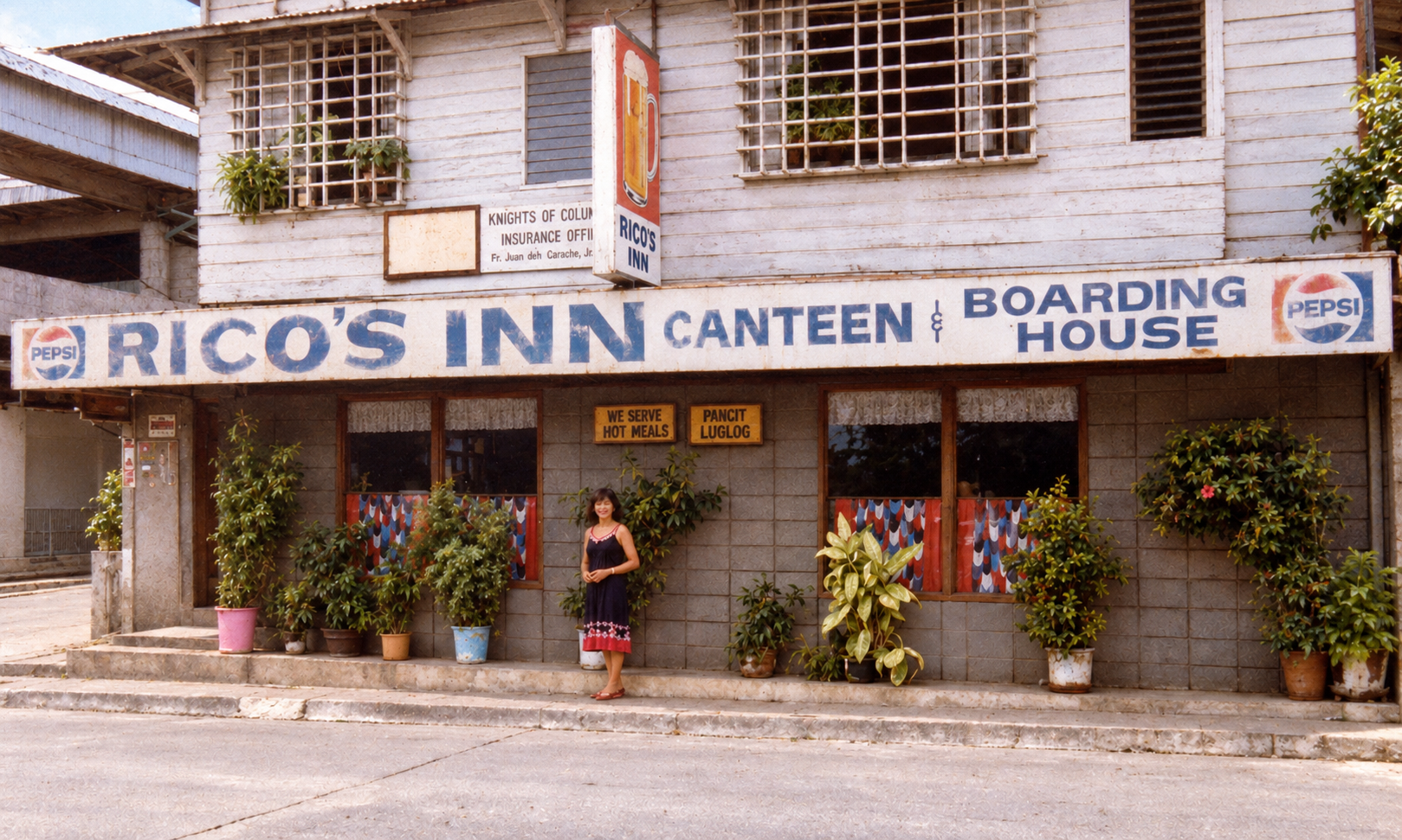 A woman standing outside Rico’s Inn Canteen and Boarding House.