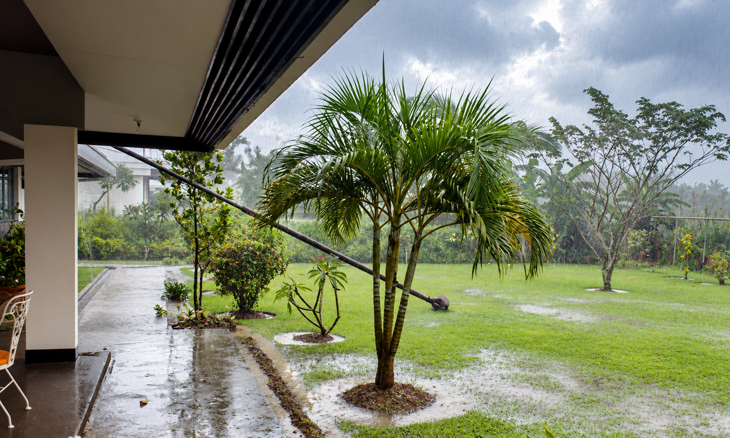Rain falling on the garden and flooded lawn, viewed from the covered porch.